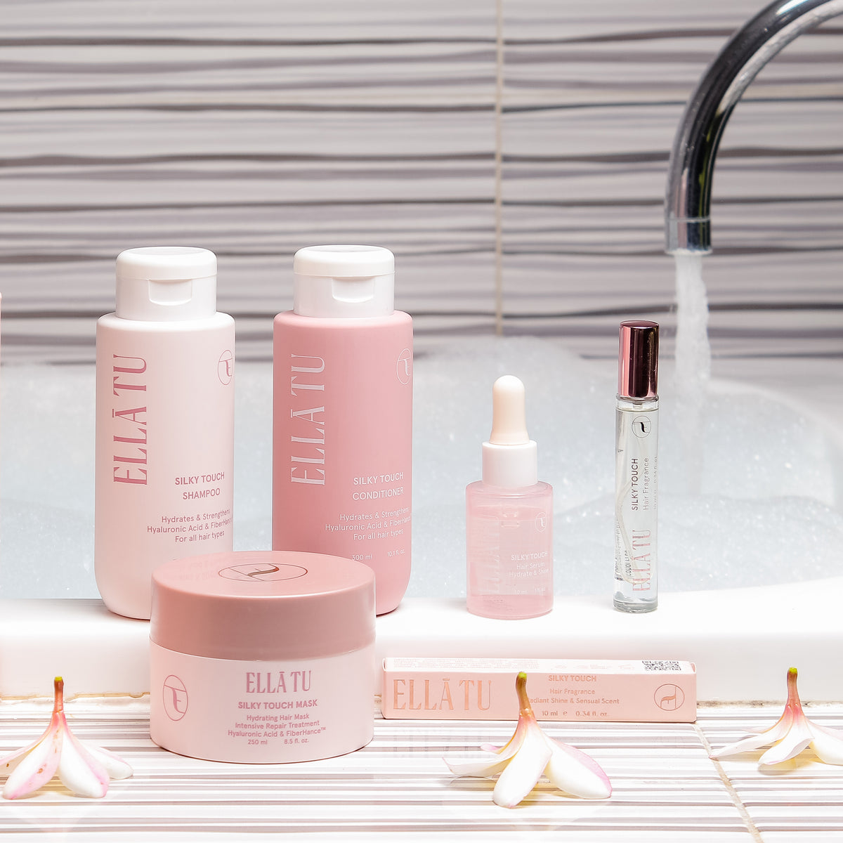 סדרת SILKY TOUCH של ELLĀTU באמבטיה: שמפו, מרכך, מסכה, סרום ובושם לשיער